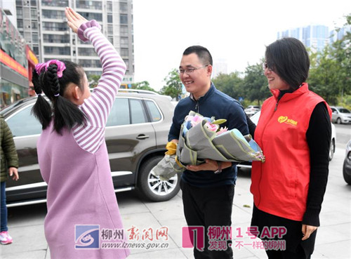 在来宾市凤临路1号亲水河畔小区,一名小朋友向宓学万献花,欢迎大哥哥回家.jpg 在来宾市凤临路1号亲水河畔小区,一名小朋友向宓学万献花,欢迎大哥哥回家.jpg