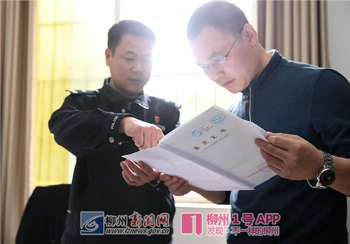 2月28日,在广西柳州市公安局荣军派出所,民警谢桂刚给宓学万讲解鉴定文书原件上的DNA鉴定结果.jpg 2月28日,在广西柳州市公安局荣军派出所,民警谢桂刚给宓学万讲解鉴定文书原件上的DNA鉴定结果.jpg