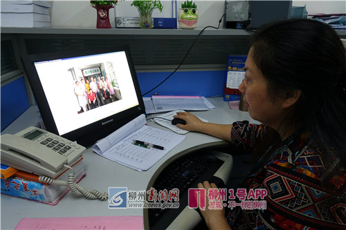 唐凤元正在查看当年的老照片 付华周摄.jpg 唐凤元正在查看当年的老照片 付华周摄.jpg