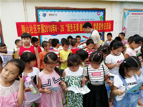 图为社区工作人员在给学生们发放禁毒资料.jpg
